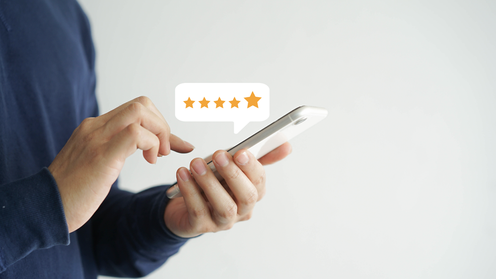 Person tapping smartphone screen to submit a five-star customer rating