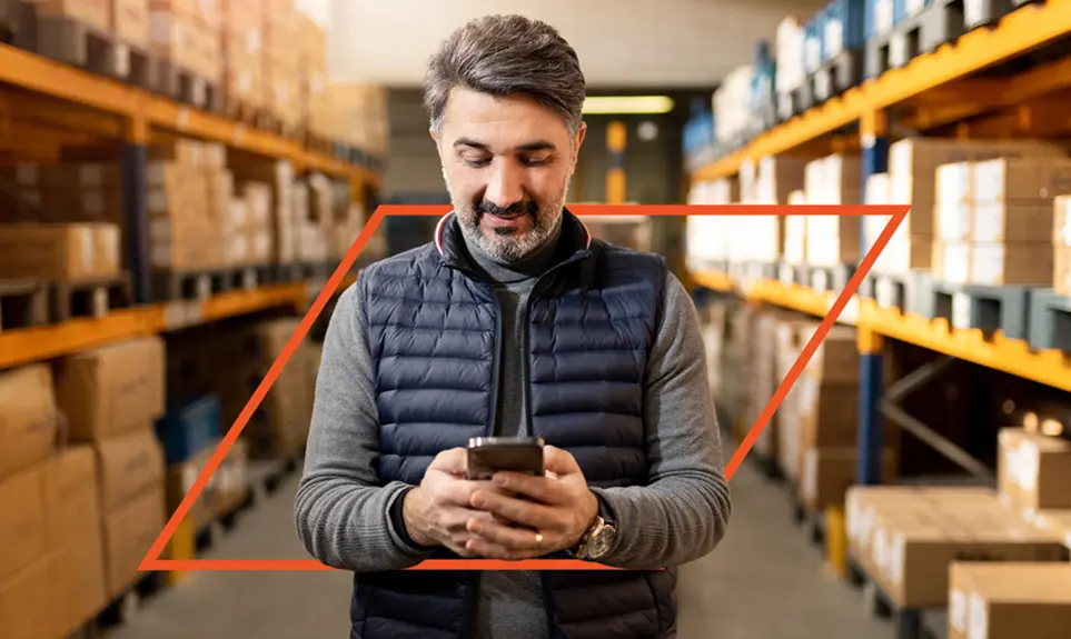 Warehouse manager reviewing inventory or job details on mobile device