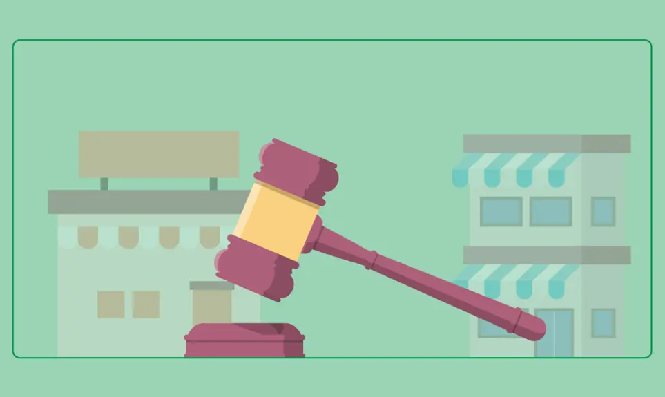 Gavel striking sound block in front of small business storefronts representing legal regulations for contractors