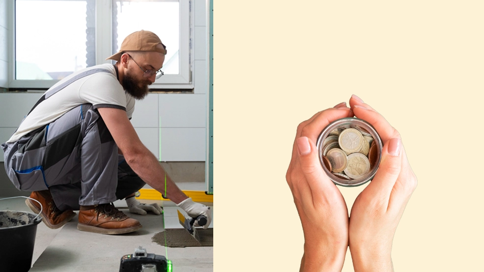 Tile installer laying floor tiles in a bathroom next to hands holding a jar of coins representing cost savings