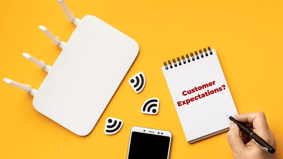 WiFi router with antennas next to smartphone and notepad showing "Customer Expectations?" text