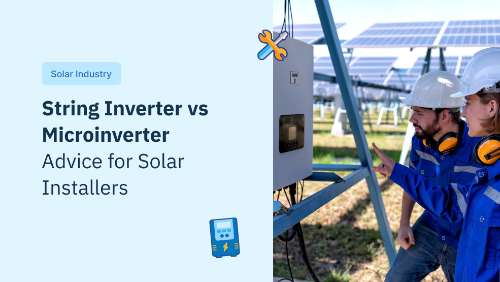 Two solar technicians in safety gear examining a string inverter unit at a solar panel installation site
