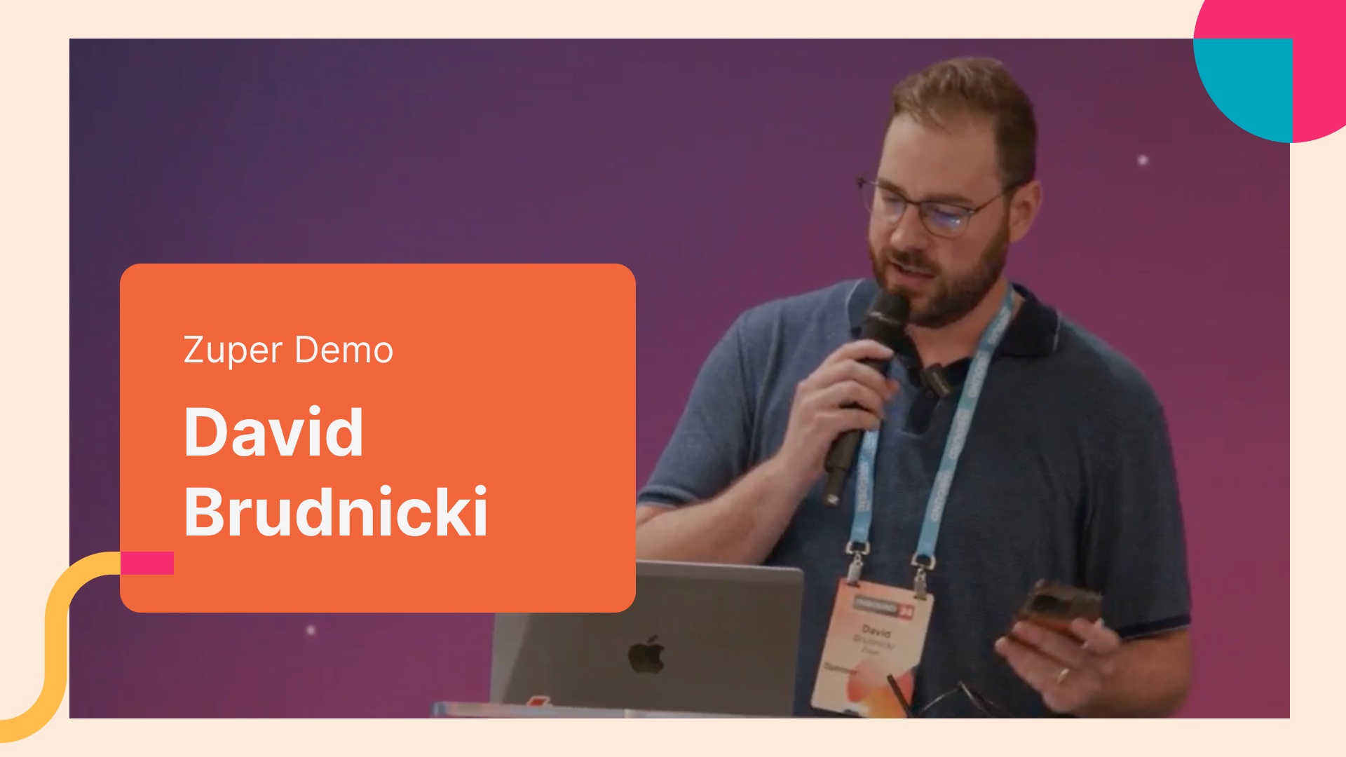 David Brudnicki presenting a Zuper demo at a conference while holding a microphone and smartphone