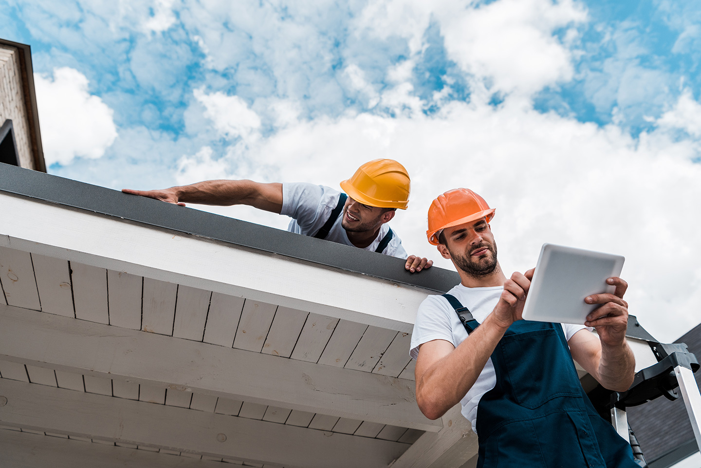 Roofers discussing the best field service management software options on a tablet